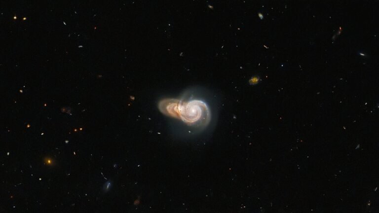 “Hubble’s Discovery: Overlapping Spiral Galaxies Revealed in Cosmic Snapshot”